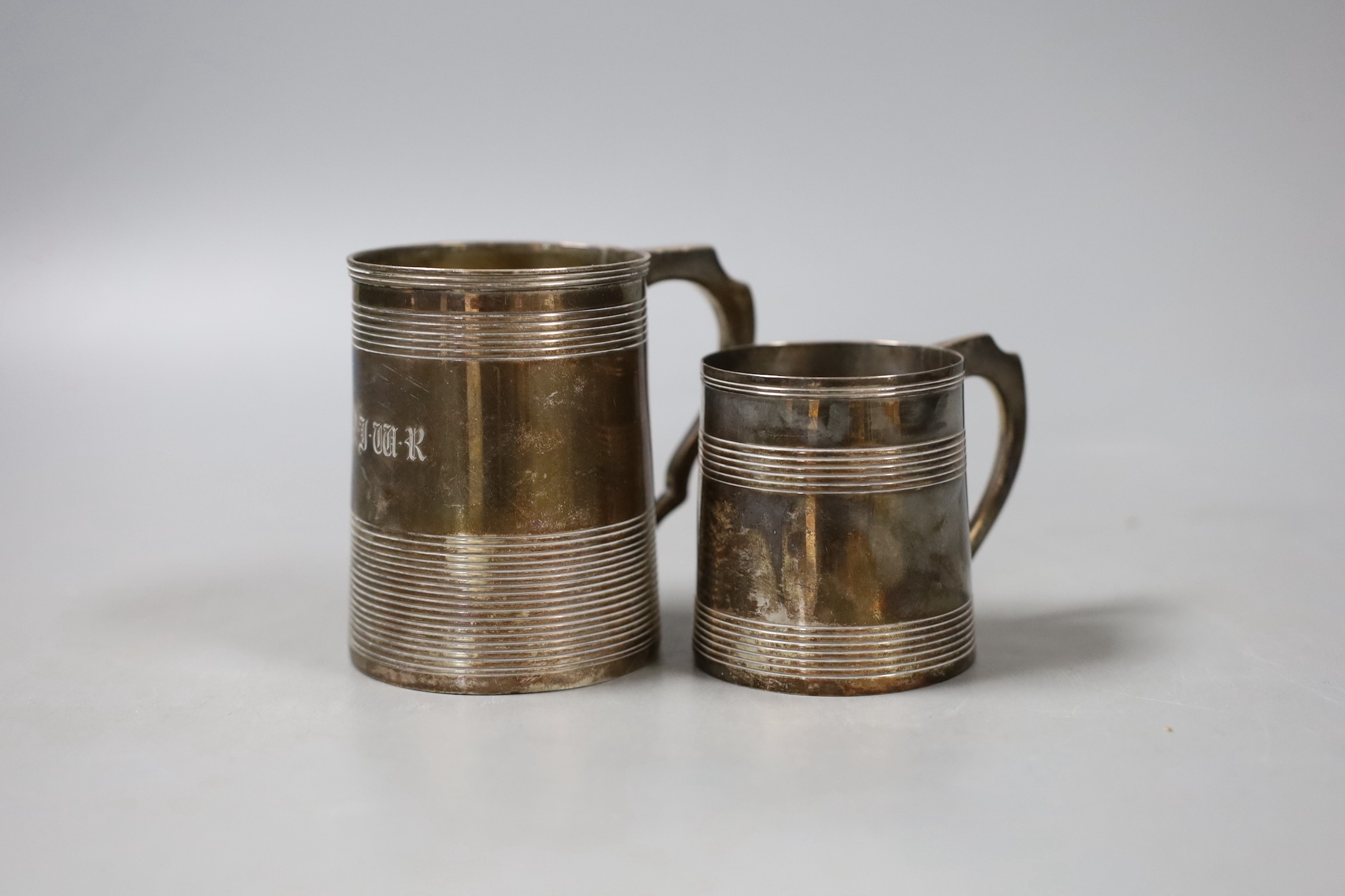 Two George III silver christening mugs, both with reeded bands, Thomas Meriton, London, 1801, 62mm and Charles Chesterman II, London, 1803, 83mm, the latter with later? engraved initials, 7.5oz.